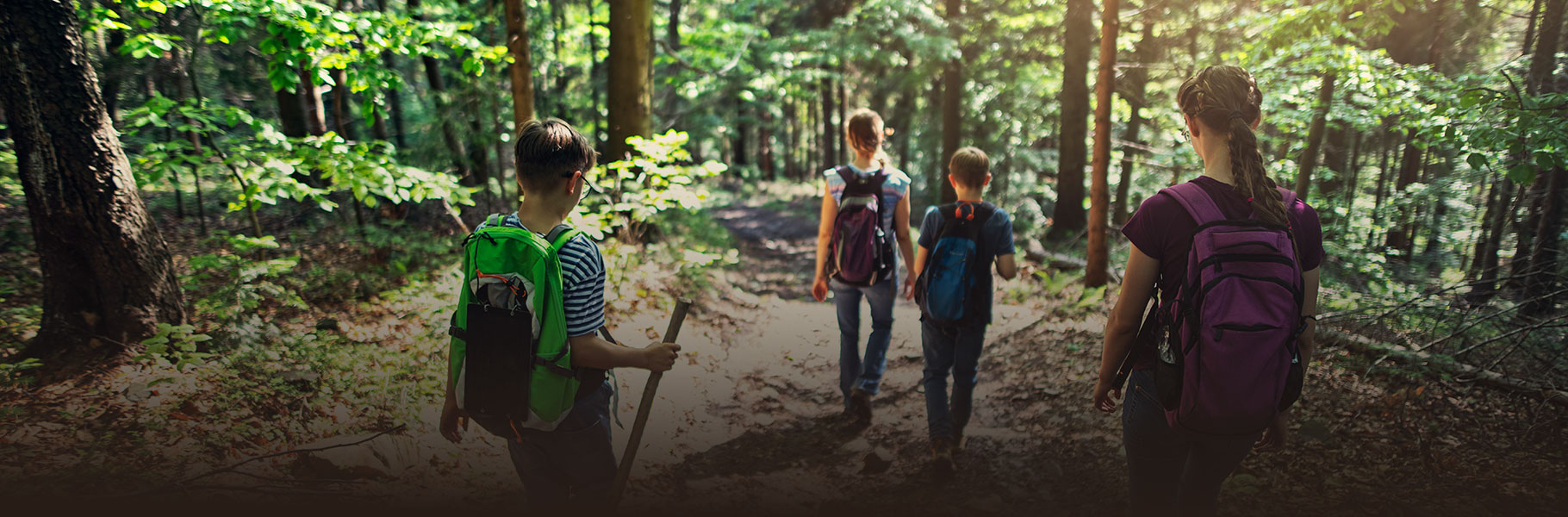 Teens walking trail in woods