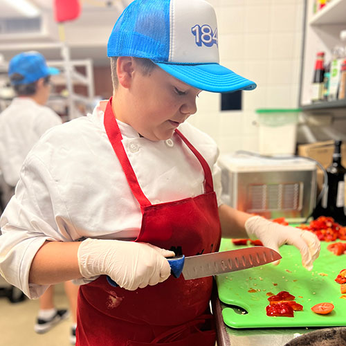 Middle school student preparing food in Rebel Chefs program