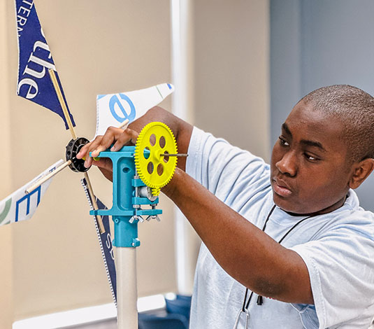 Student working on windmill mechanism in program activity
