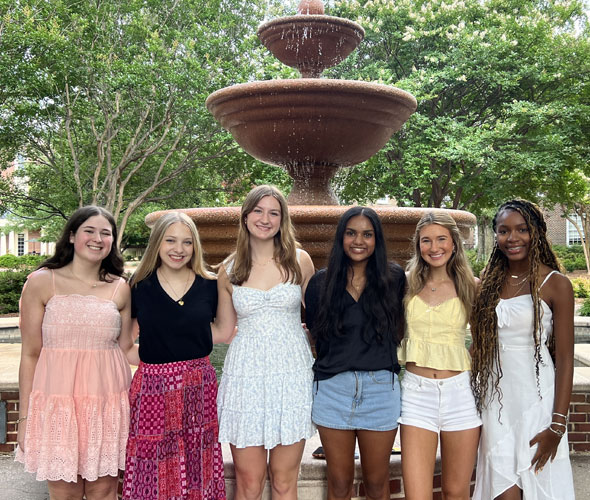 group of students looking at computer screen adn discussing