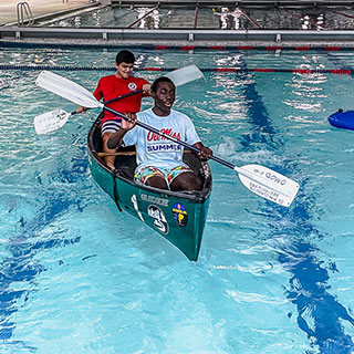 Two students learning to canoe in the Turner Center pool