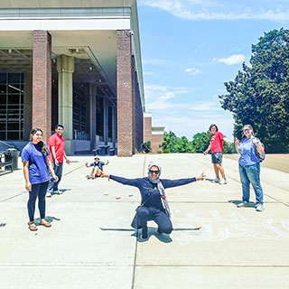 students posing with sidewalk art at student union