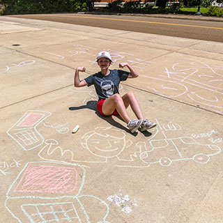 student posing with sidewalk art at student union