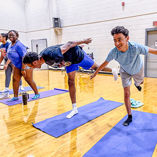 students on exercise mats doing balancing exercise